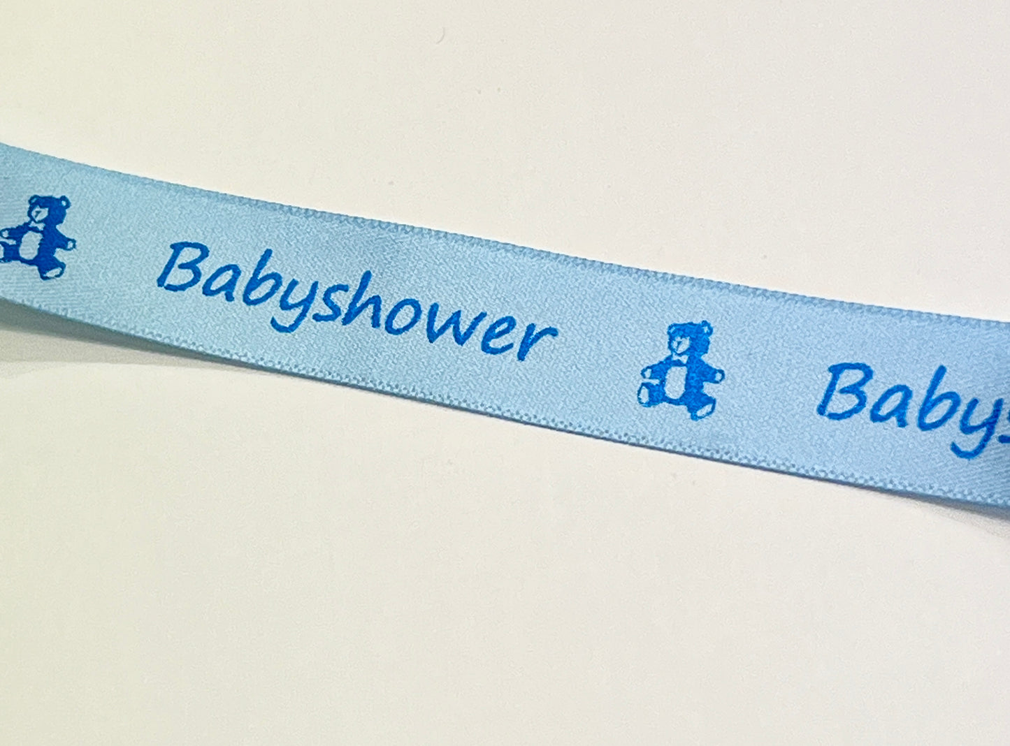Bånd med tekst « Babyshower ». Lys blå 15mm . Tema: baby shower