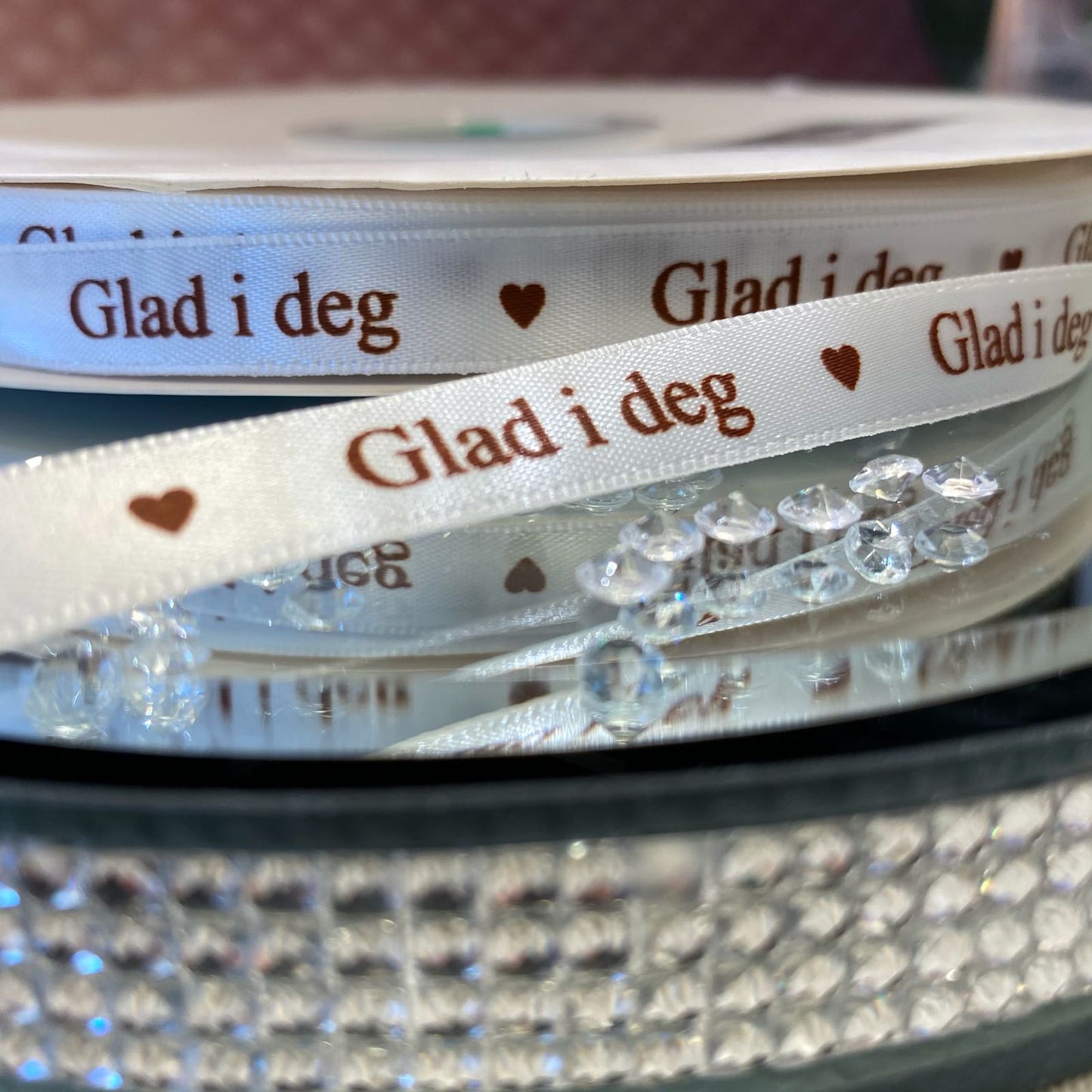 Bånd med tekst hvitt med brun tekst « Glad i deg »