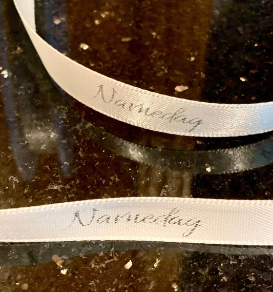 Bånd med tekst «Navnedag», offwhite m/sølvskrift. 10mm