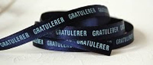 Bånd med tekst mørk blå med lys blå tekst : « Gratulerer »