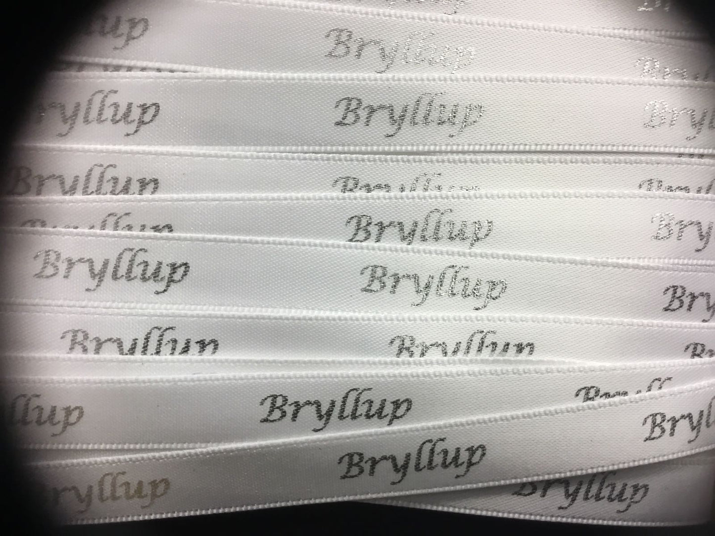 Bånd med tekst " Bryllup ", hvitt m/sølvskrift. 10mm bredde.