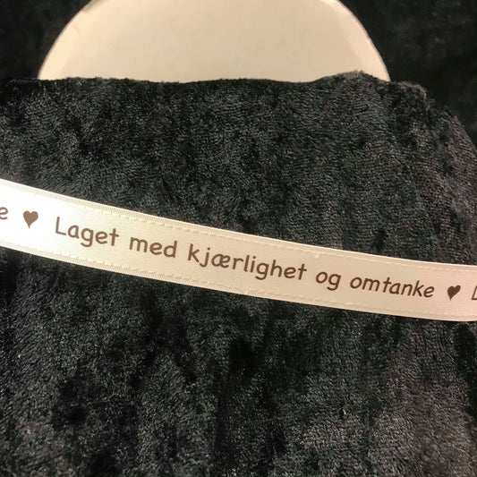 Bånd med tekst. Kremhvitt silkebånd med mørkebrun skrift - "Laget med kjærlighet og omtanke"