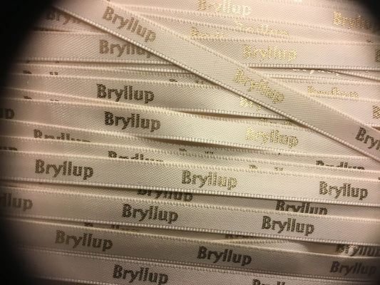 Kremhvitt silkebånd med gullfarget skrift « Bryllup» b: 7 mm