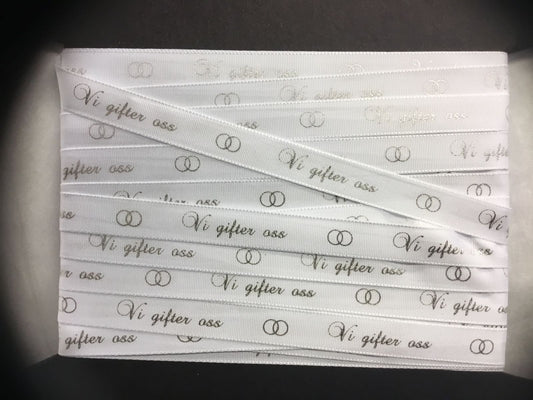 Bånd med tekst « Vi gifter oss » hvitt m/sølvskrift. 10mm bredde.
